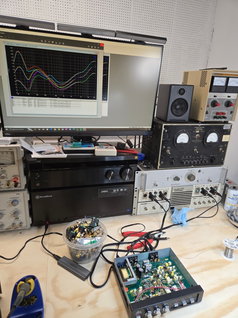 The equalizer hooked up to the Audio Precision System One analyzer, showing a complex graph of overlapping frequency response curves on the attached PC display.