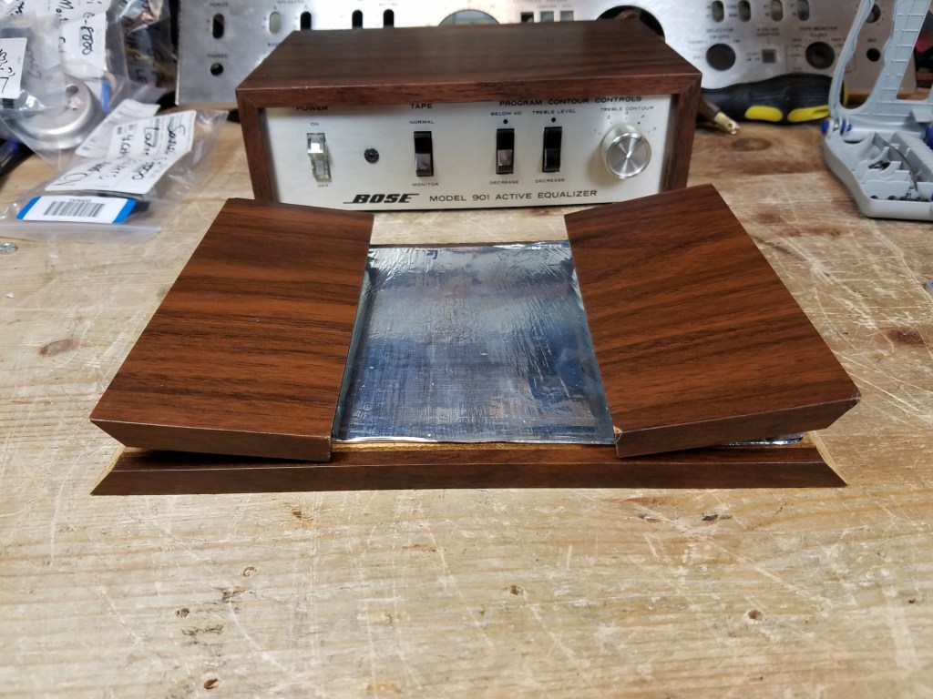 A particle board case, which was destroyed in shipping and the sides have snapped off and folded inward, held together only by the shielding tape on the inside cover.