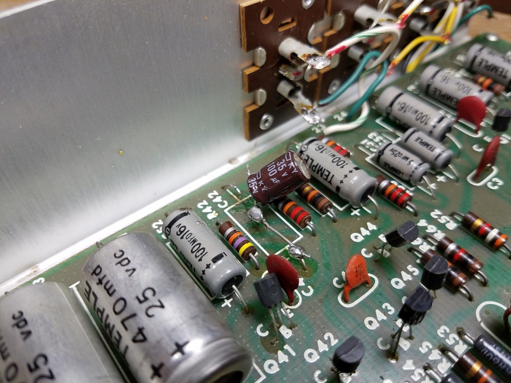 A Series II equalizer with a very badly performed repair, with one electrolytic capacitor tacked in on top and large blobs of solder visible.